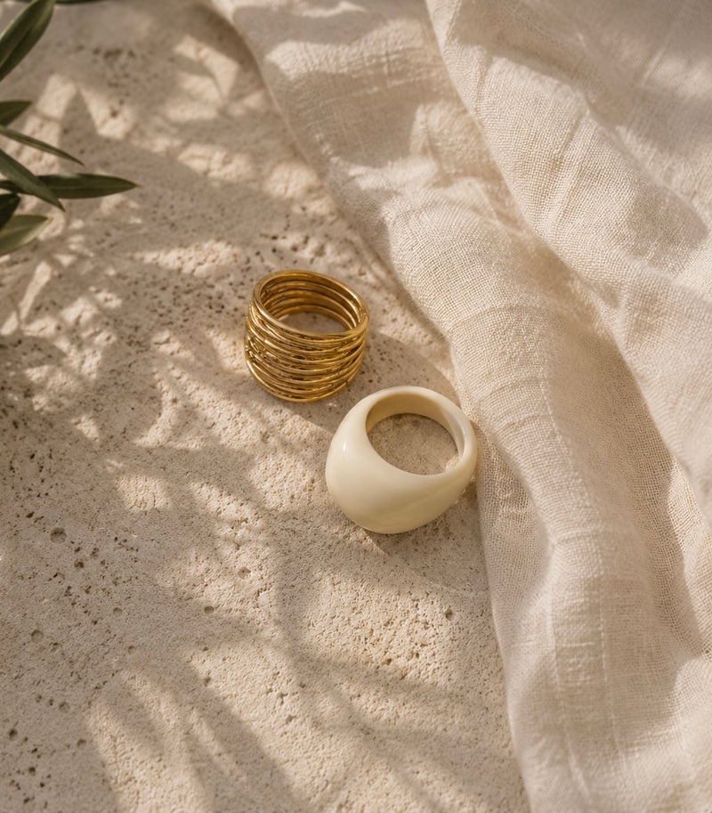 detalle de anillo dorado mediterráneo con luz suave sobre fondo lino beige
