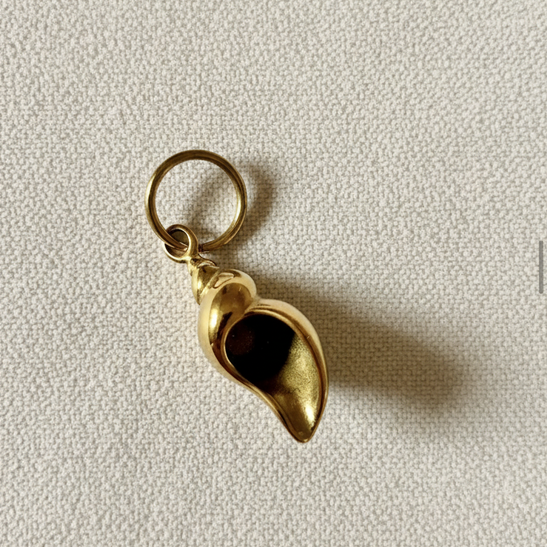 Charm Concha Bold dorado sobre fondo crema