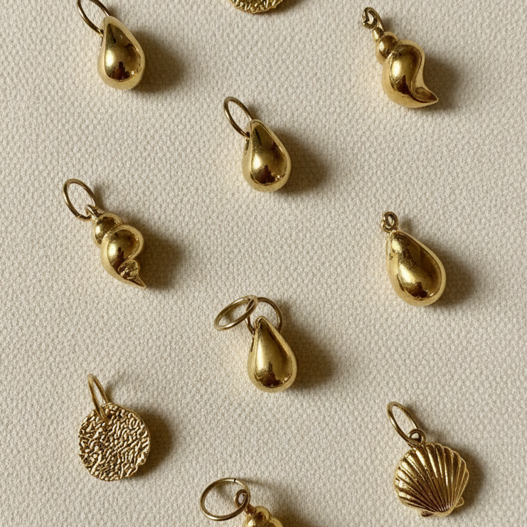 Varias unidades del charm Medalla Gold sobre fondo crema